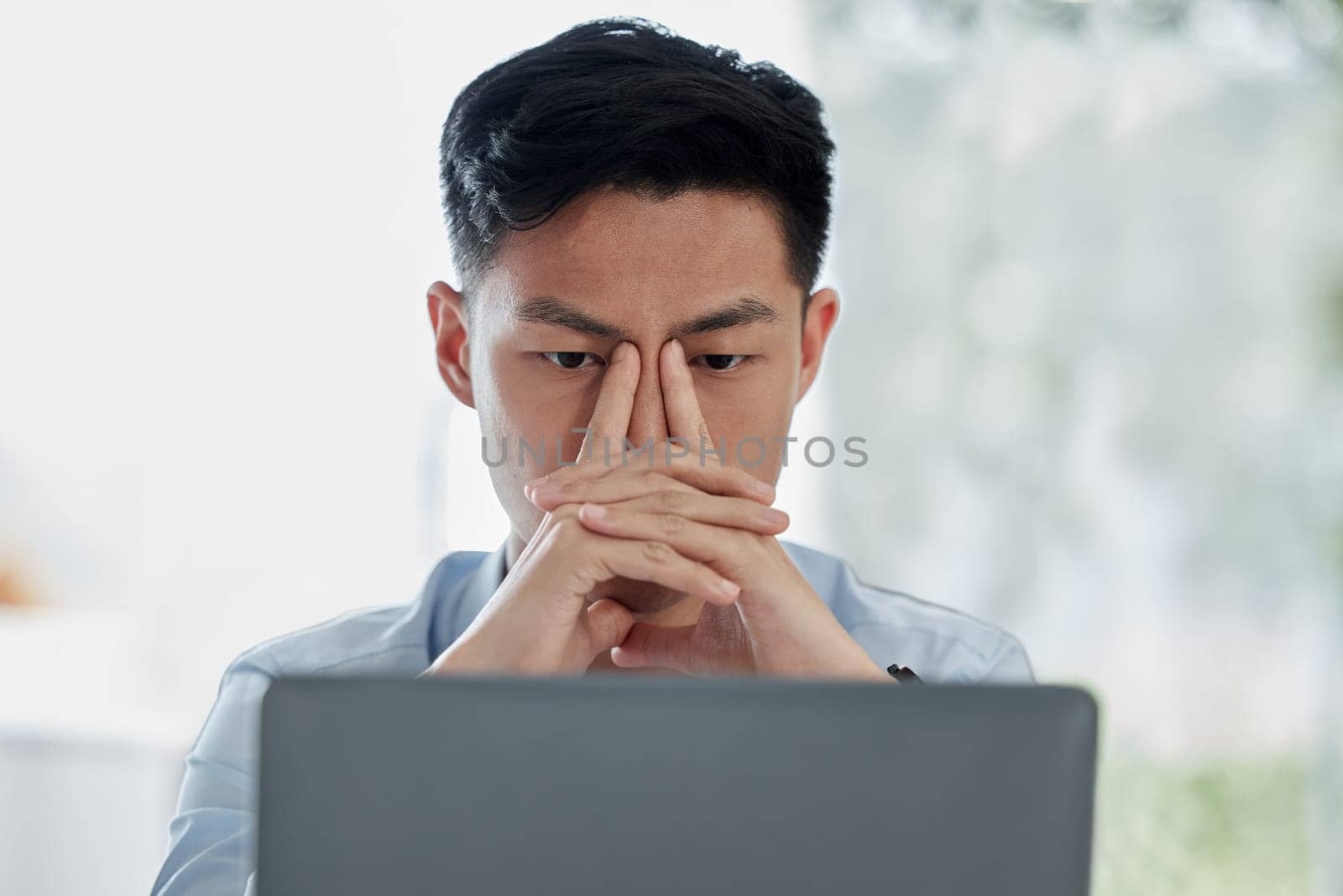 Asian man, laptop and headache with stress in mistake, debt or financial crisis from stock market crash. Businessman or frustrated broker with migraine on computer in burnout, anxiety or depression by YuriArcurs