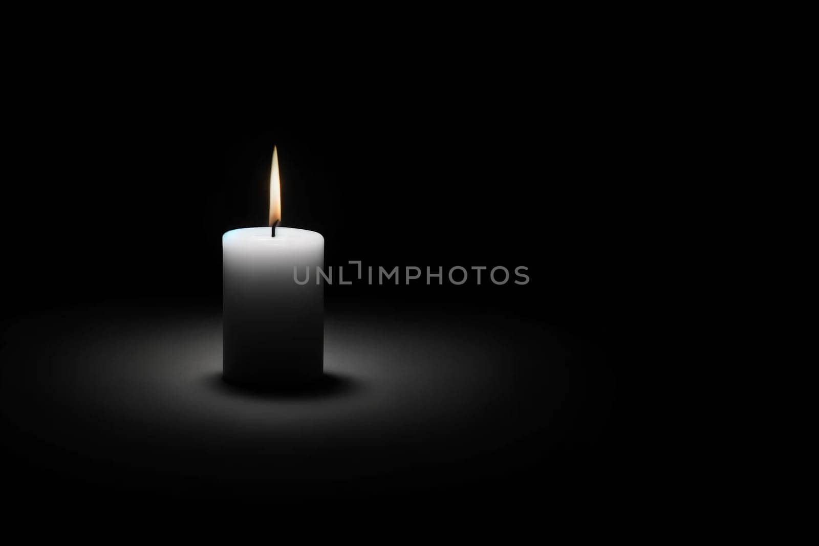 burning white candle on a black background, copy space.