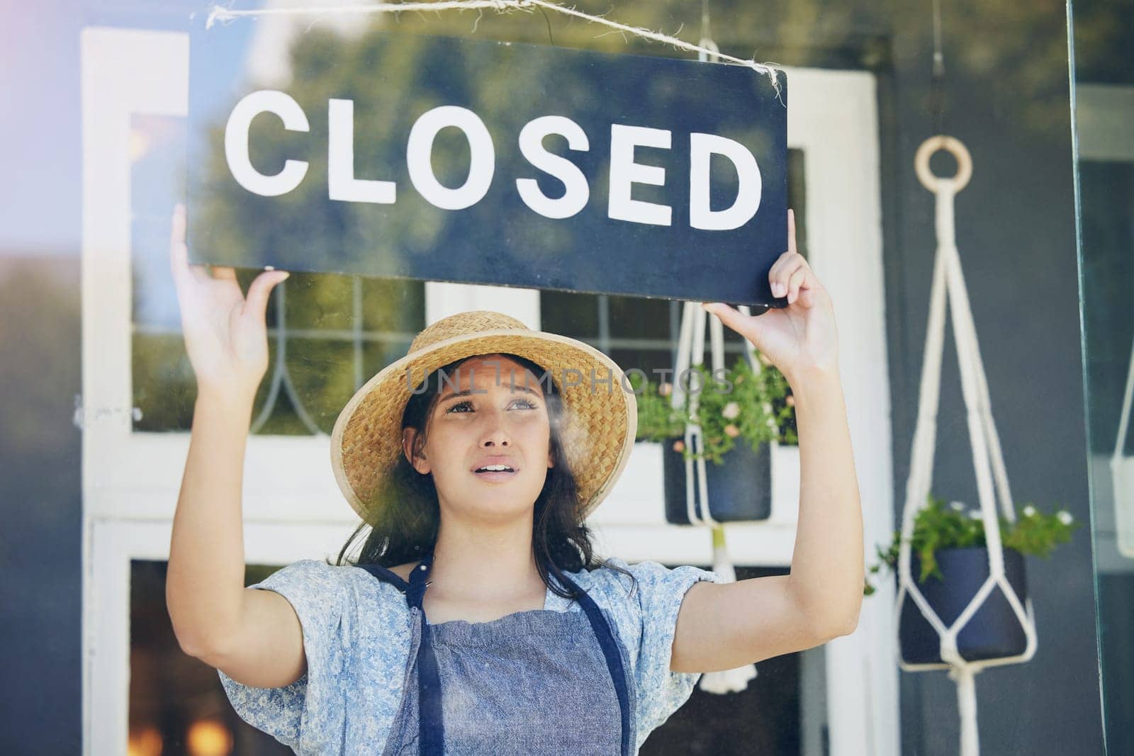 Closed, woman and floral business with sign, recession and inflation with bankruptcy, emotion and failure. Person, entrepreneur or worker with unemployment, stagflation or stress with store or upset.