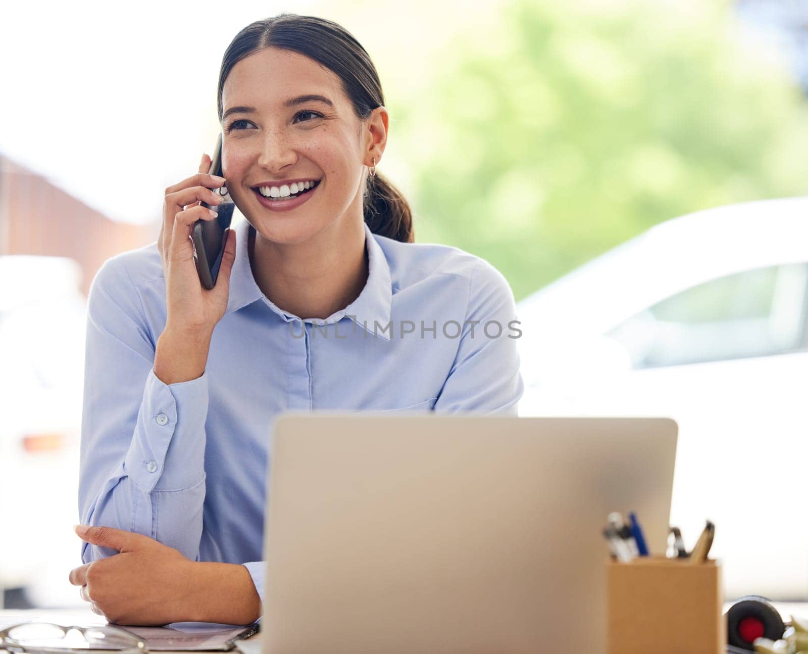 Happy, business woman and phone call with laptop for financial discussion, proposal or communication at office. Female person, employee or accountant with smile for conversation in finance at desk.