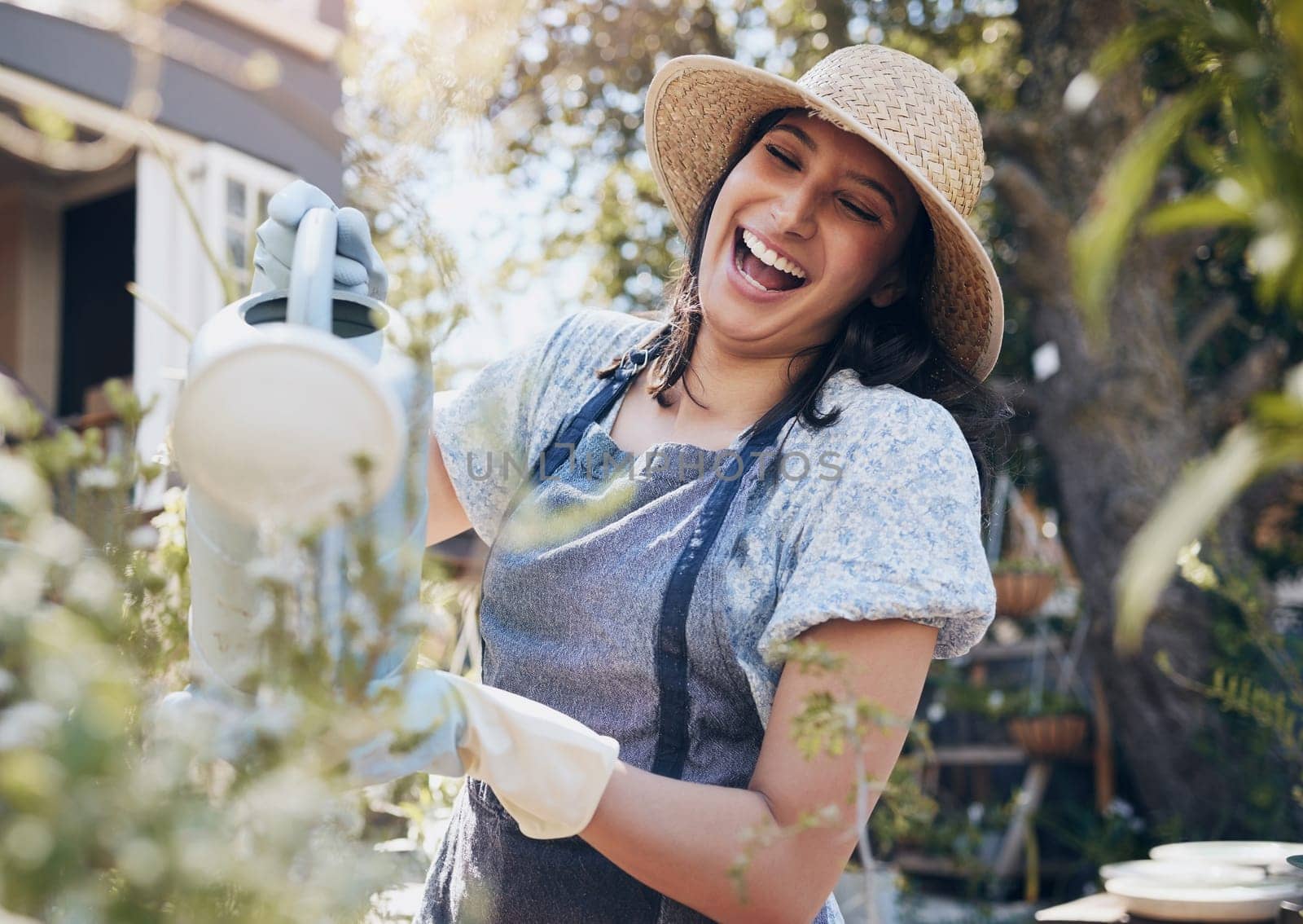 Laughing, watering and woman gardening with plants for growth, development and irrigation of agriculture. Happy, funny florist or girl farming for fresh nature, horticulture and floral sustainability.