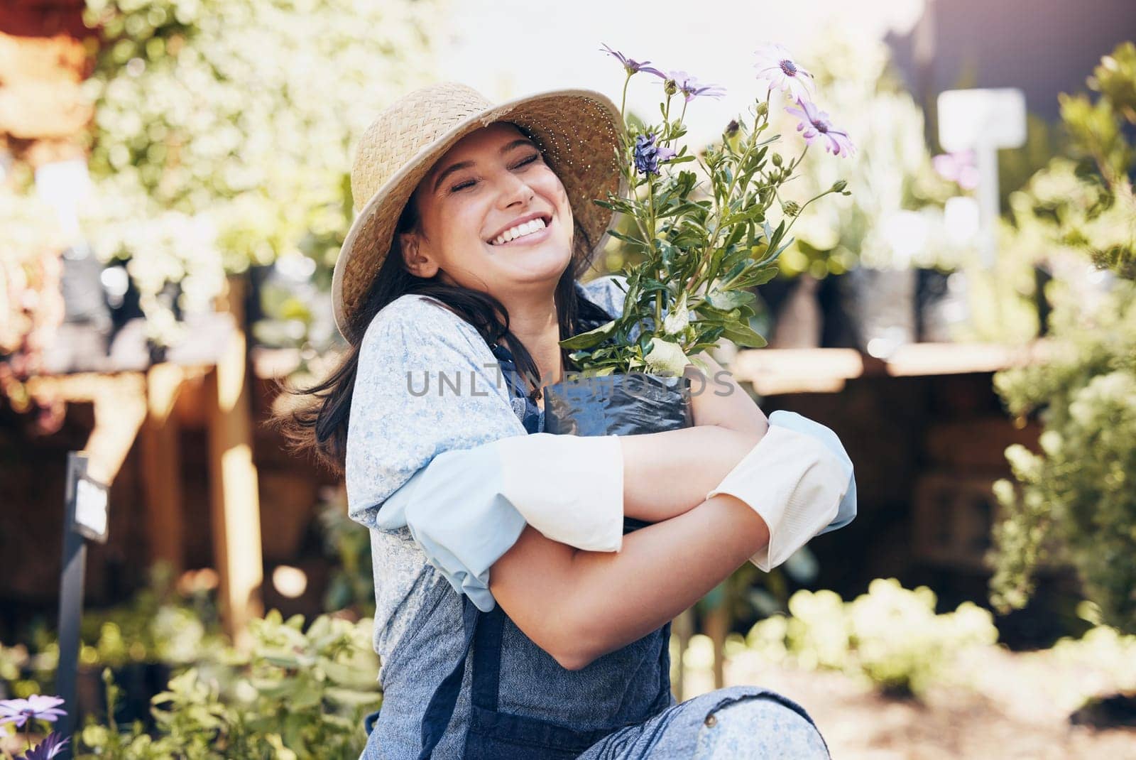 Plant, outdoor garden and smile of woman hug flowers for environment, sustainability or ecology. Nature, happiness and female person for green nursery, agriculture or landscaping in backyard by YuriArcurs