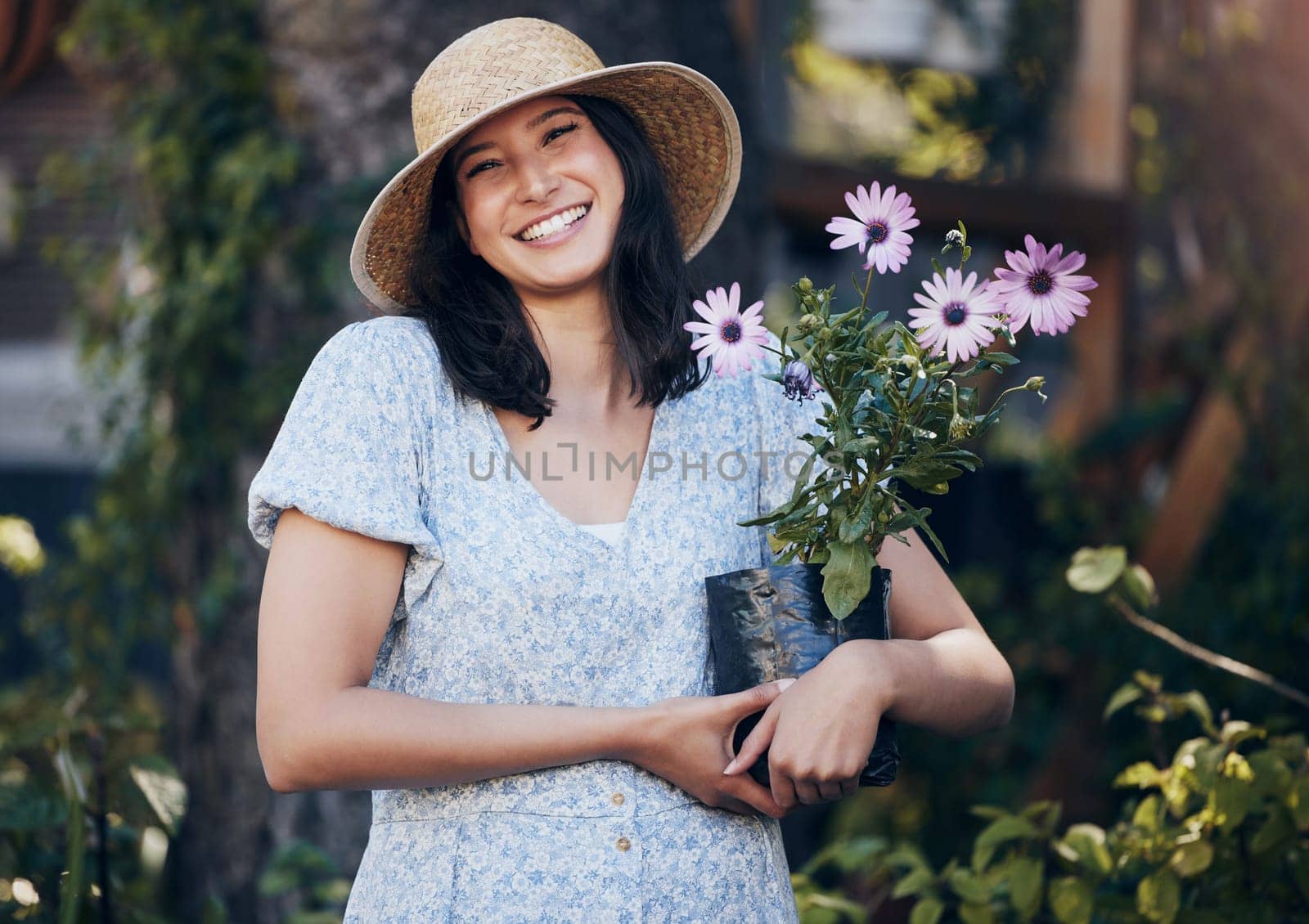 Portrait, happy woman and holding plant in outdoor garden for environment, sustainability or ecology. Nature, smile and person with flowers for green nursery, agriculture or landscaping in backyard by YuriArcurs