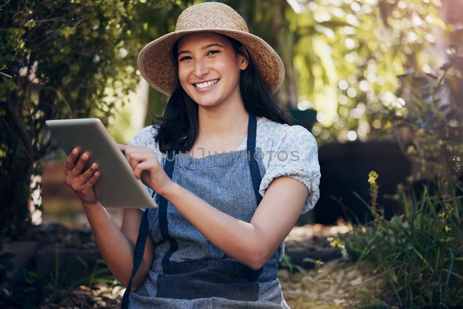 Tablet, smile and portrait of woman in garden for agriculture, farm or sustainability in Brazil. Face, tech and happy person in greenhouse nursery for ecology, growth or florist check natural plants by YuriArcurs