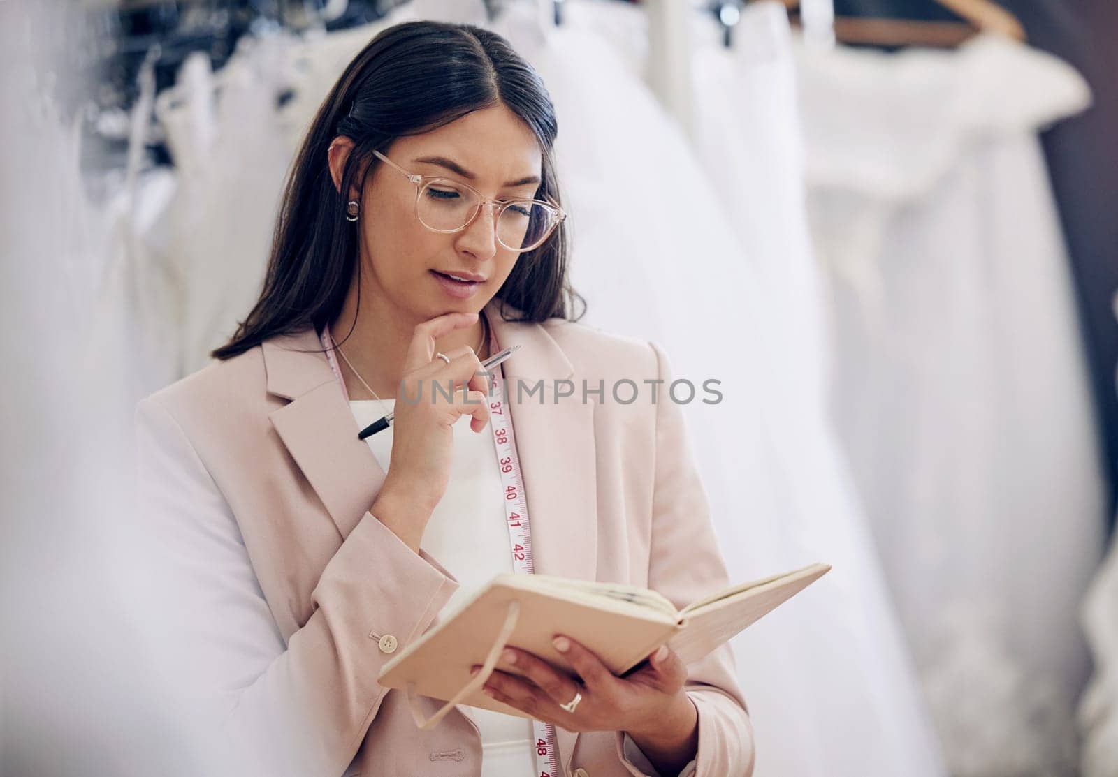 Thinking, woman or fashion designer with book for clothes ideas in store, dream or brainstorming at retail startup. Vision, tailor or creative worker planning with journal at boutique for inspiration.