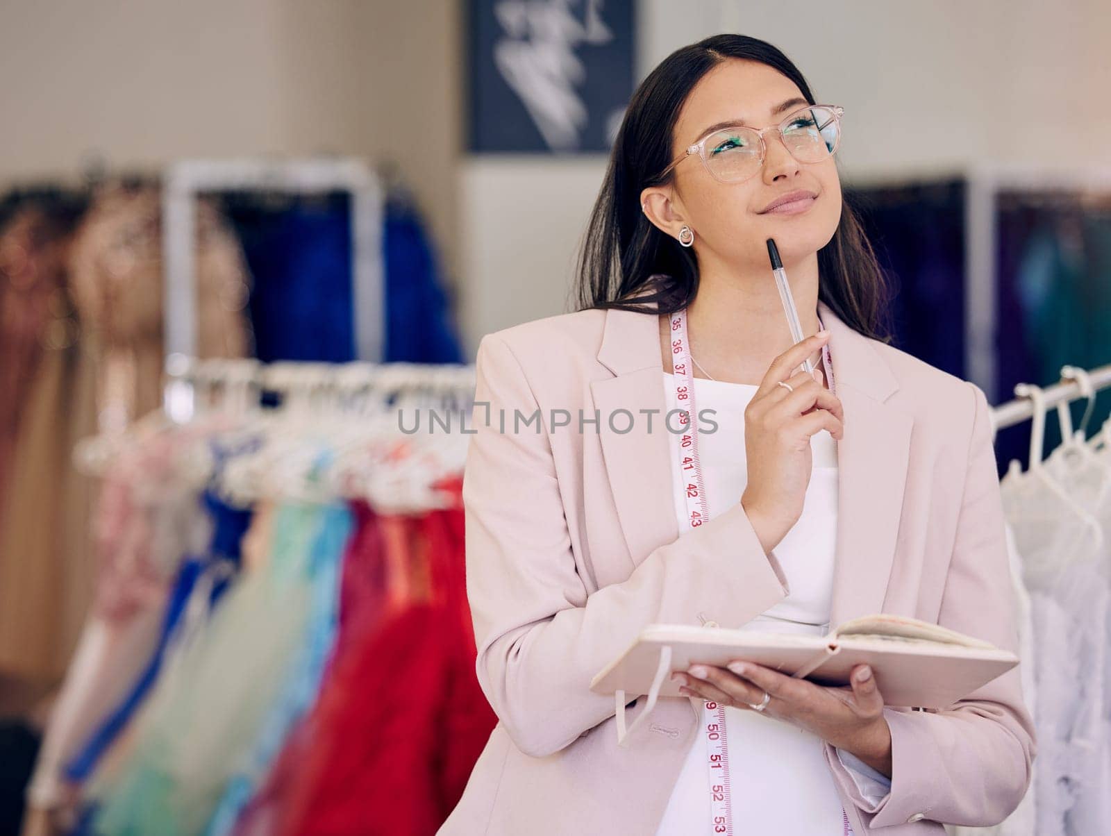 Thinking, woman or fashion designer with notebook for idea in clothes store, dream or brainstorming at retail startup. Book, tailor or creative worker planning at boutique for inspiration or decision by YuriArcurs
