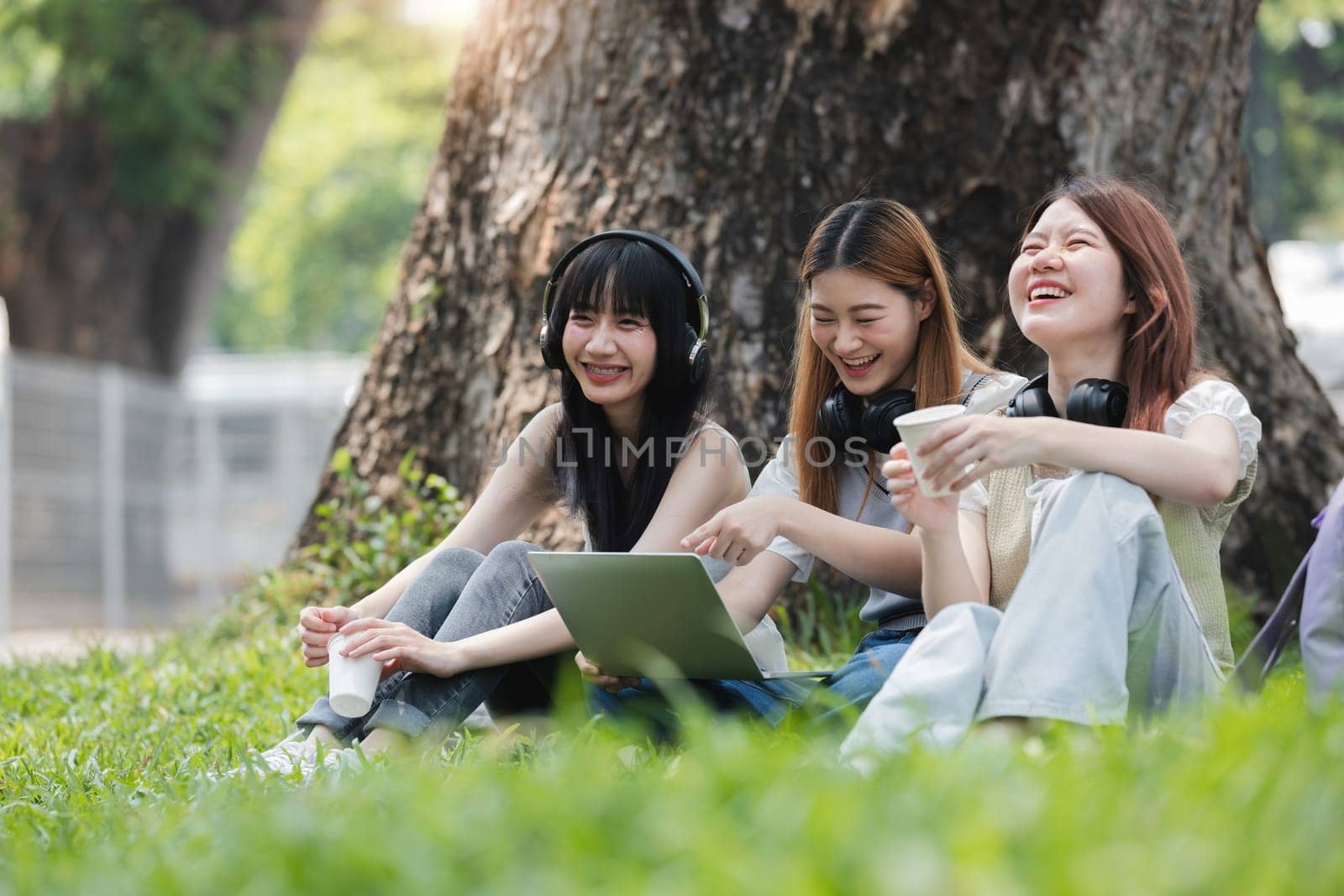 Group Of Young Asian Students Collaborating Outdoors at University. Teamwork and Knowledge Sharing. Asian Students Engaged in Collaborative Learning Outdoors. by wichayada