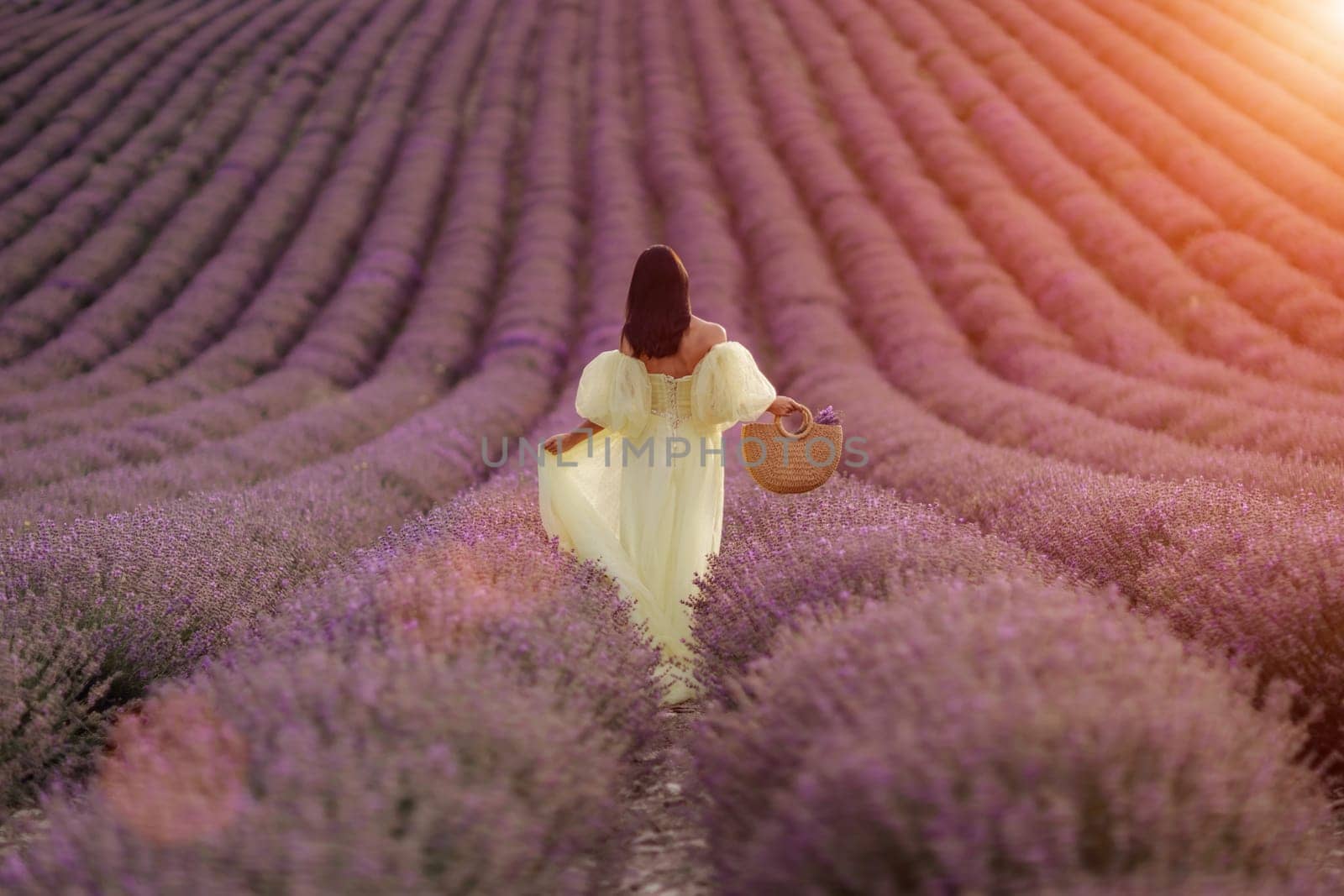 A woman in a yellow dress walks through a field of lavender. The scene is serene and peaceful, with the woman's presence adding a sense of calm to the landscape