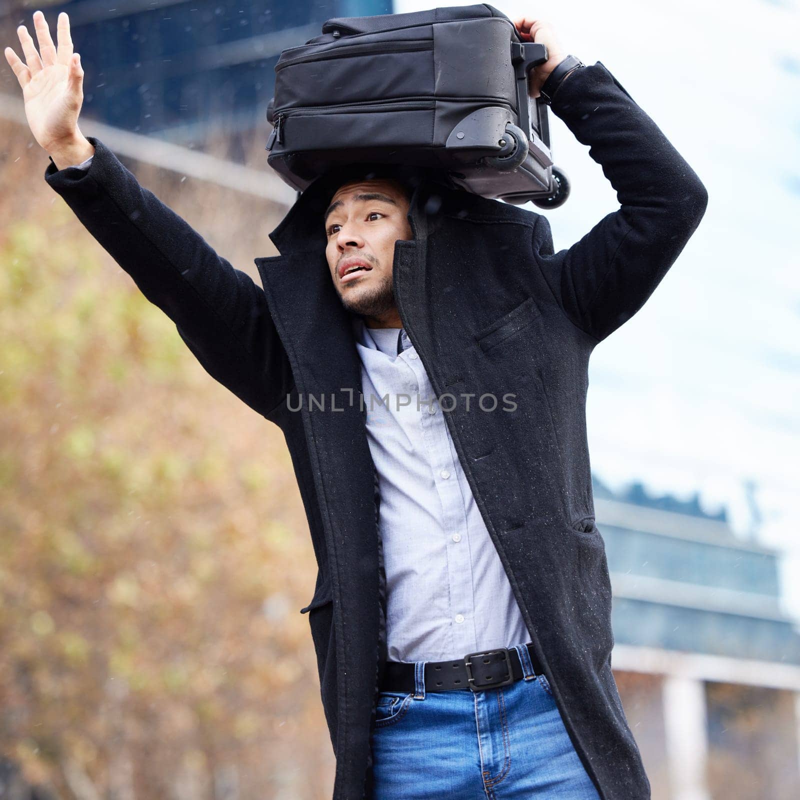Man, rain and waiting for taxi in city with luggage on head, sign and wave for driver in street. Business person, sidewalk and stop car for ride, transport or travel with storm on commute to airport by YuriArcurs