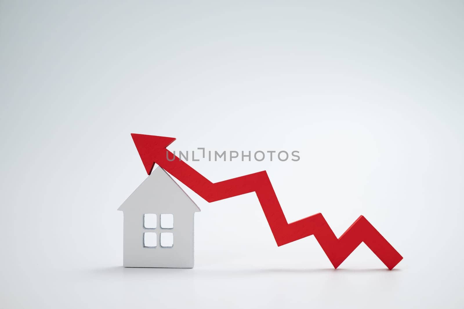 a red up arrow and house. The concept of the rising price of real estate by zartarn