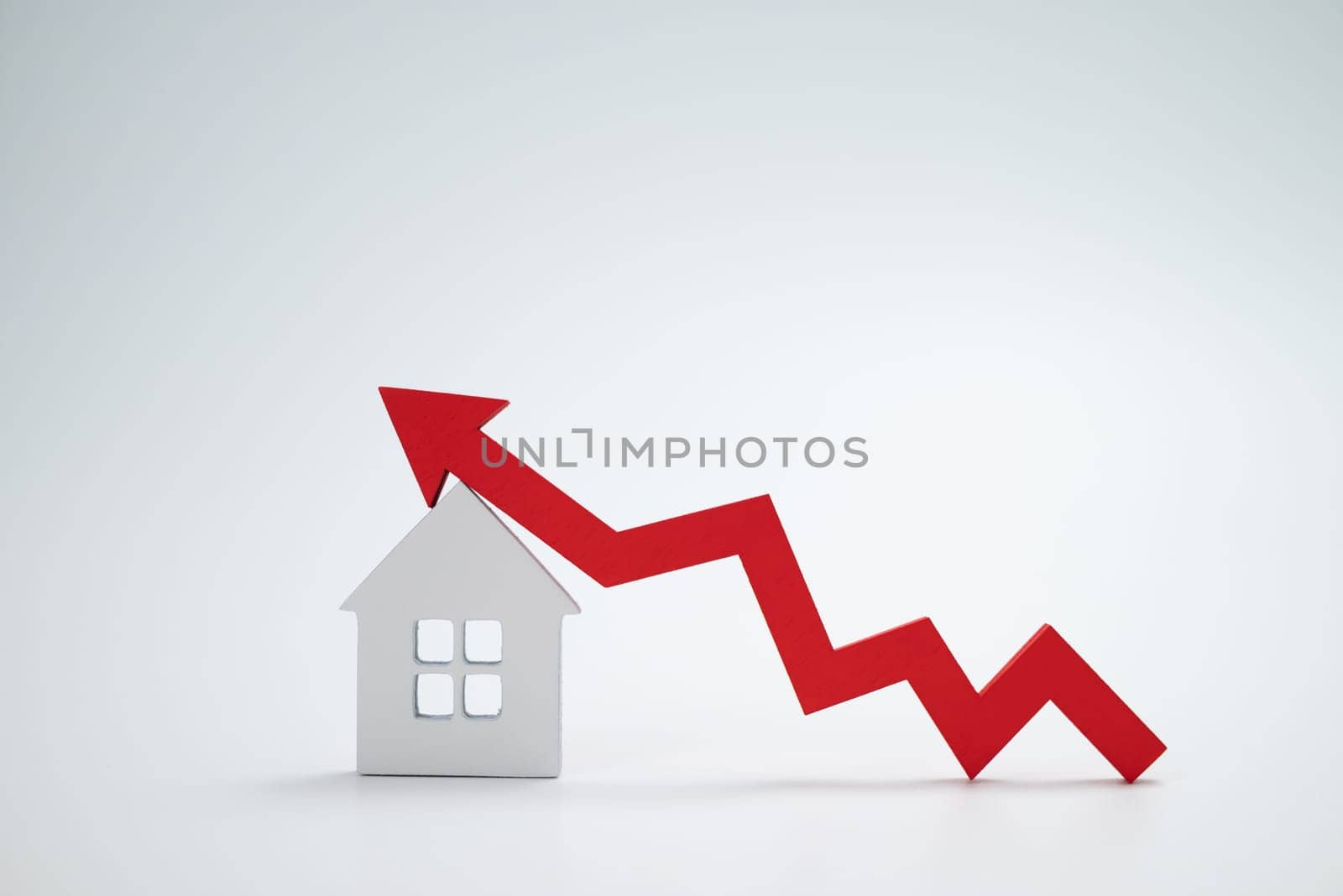 a red up arrow and house. The concept of the rising price of real estate