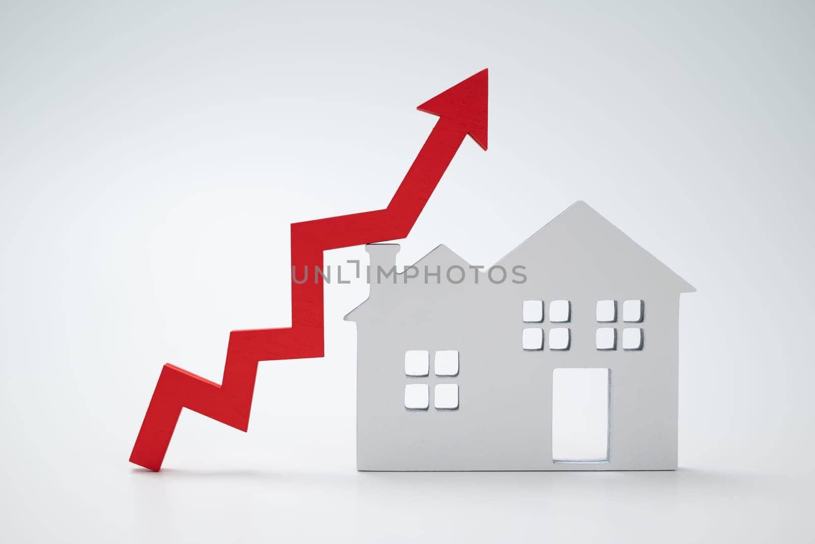 a red up arrow and house. The concept of the rising price of real estate