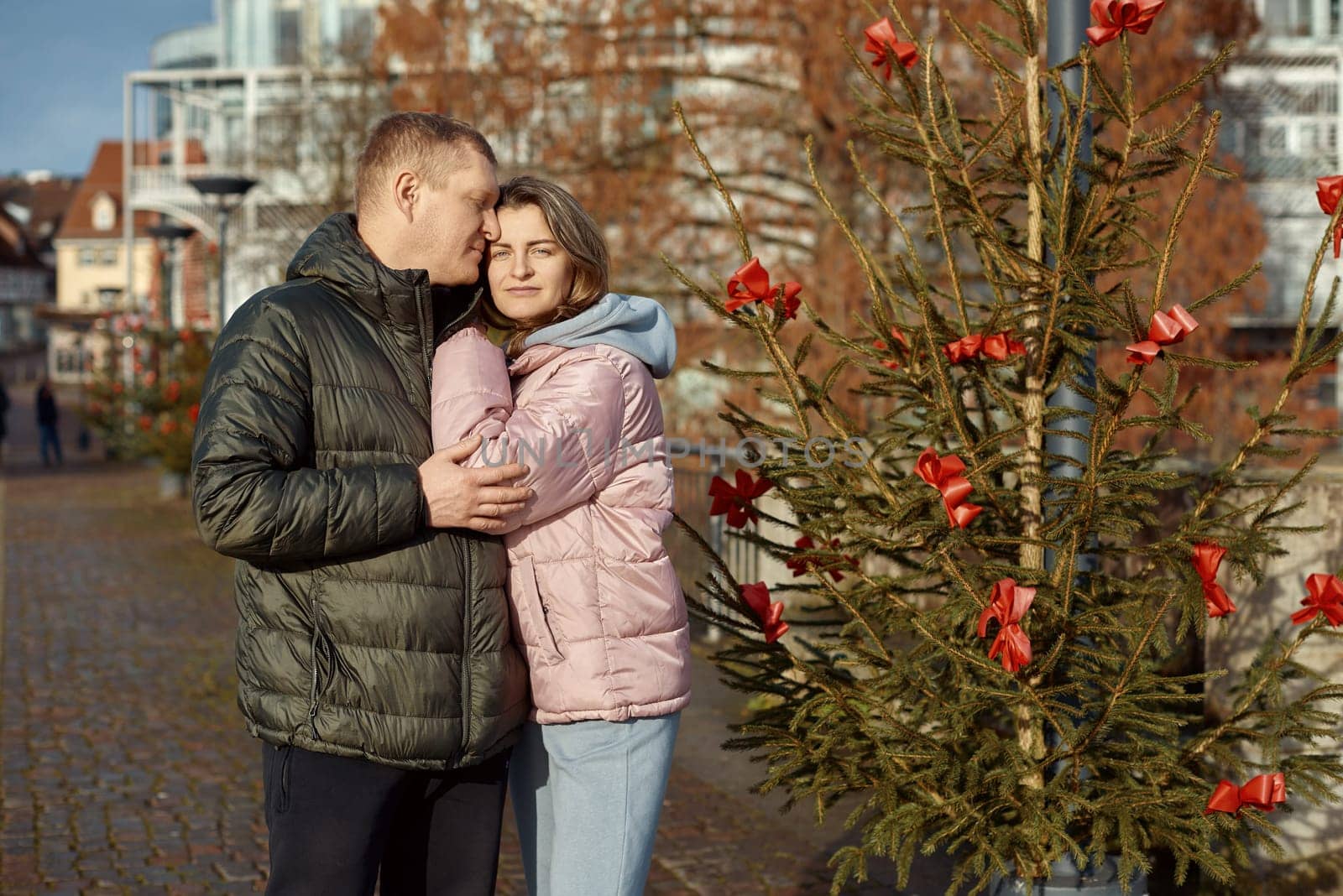 Portrait of young attractive people, lovely couple enjoying cozy atmosphere on fair in Christmas Eve. Spending time together. Concept of national traditions, winter holidays, fashion, festivities