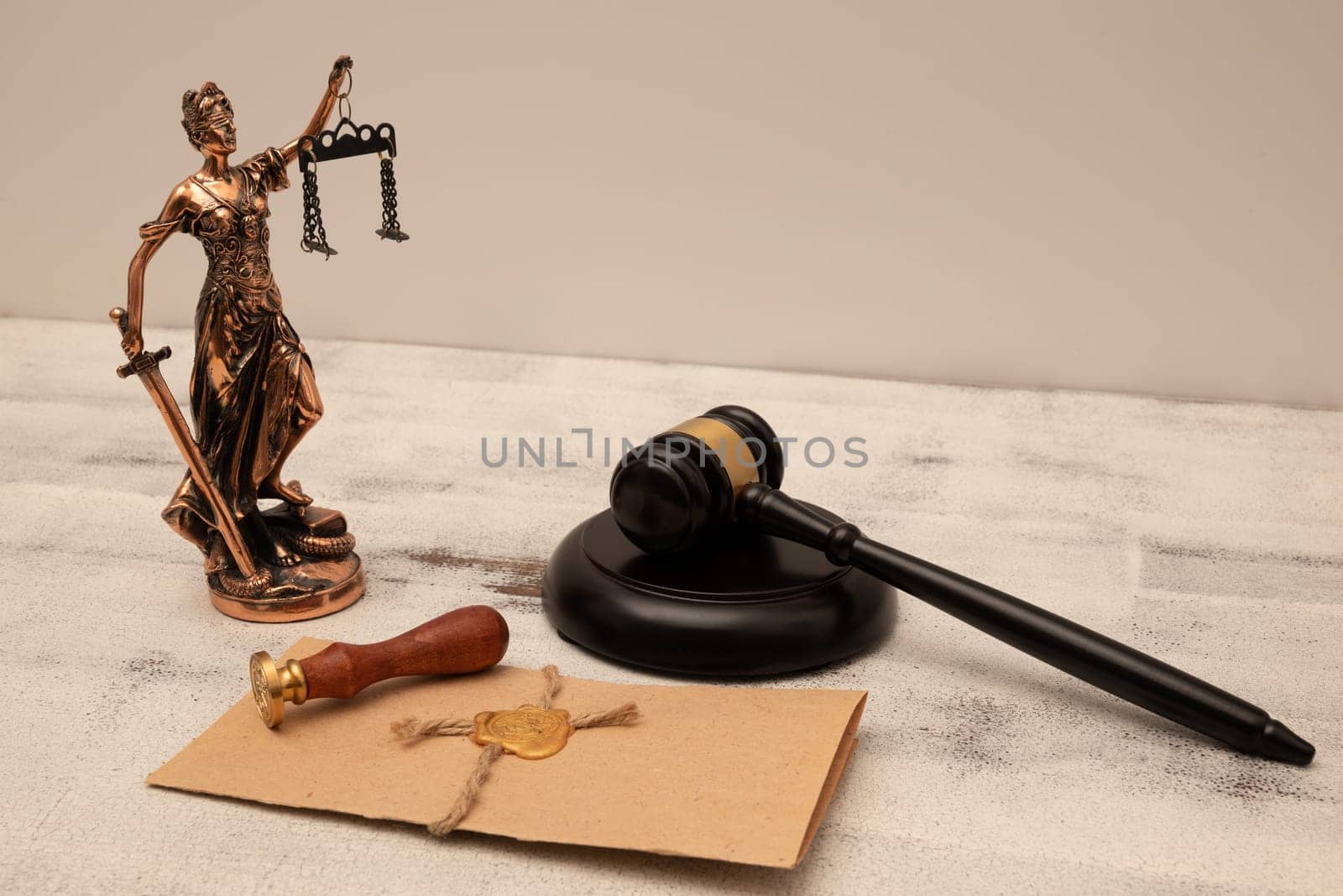 Judge's gavel, lady of justice and parchment scroll with seal and stamp on an old wooden table. Law and justice concept