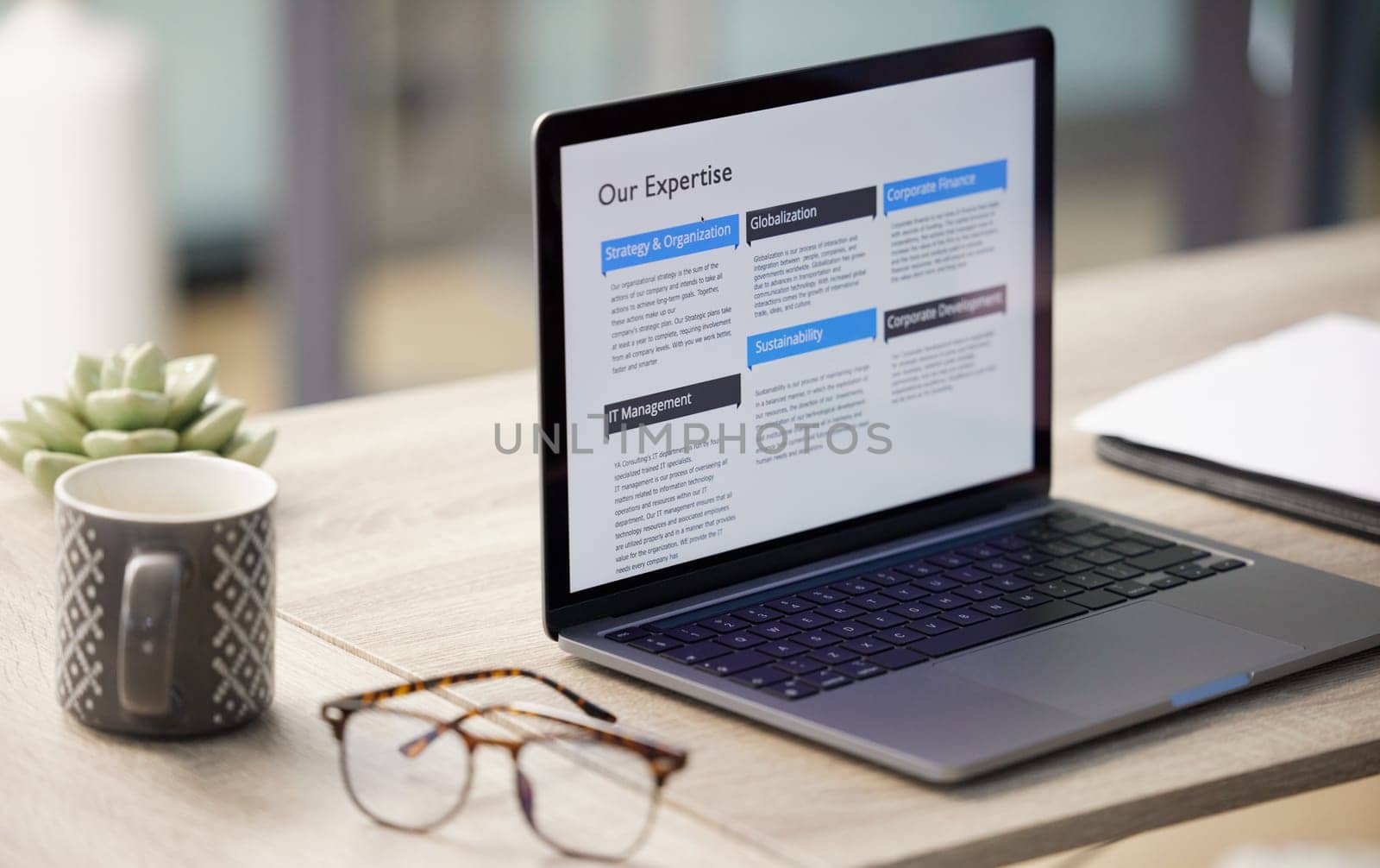 Glasses, coffee and laptop on desk in office with about us website for research or company information. Technology, spectacles and cappuccino with computer for working online by interior workplace