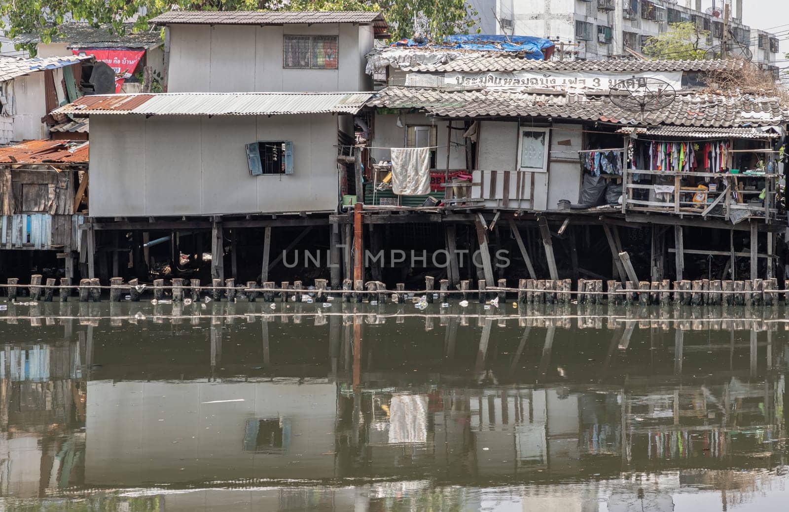 Bangkok, Thailand - Apr 20, 2024 - In slum area, the houses are old along the Khlong Phra Khanong. Broken houses are beside the Canal with dirty water. Bad pollution problem, Copy space, Selective focus.