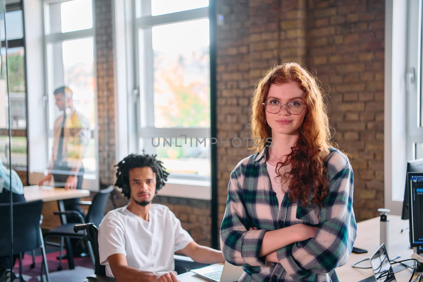 A portrait of a young businesswoman with modern orange hair captures her poised presence in a hallway of a contemporary startup coworking center, embodying individuality and professional confidence