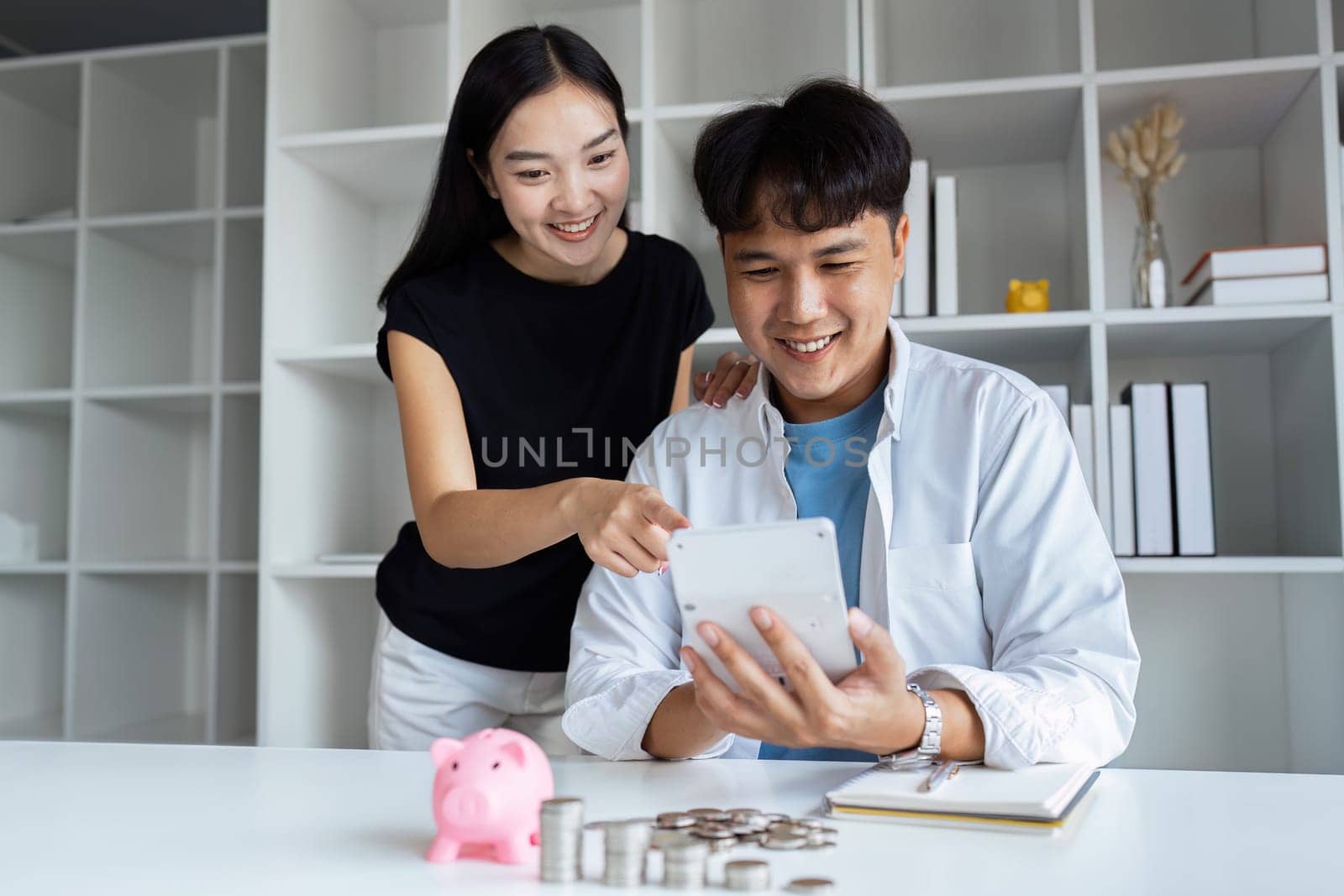Happy young couple Checking Financial Documents And Calculating Budget At Home. paying taxes, saving money concept by itchaznong