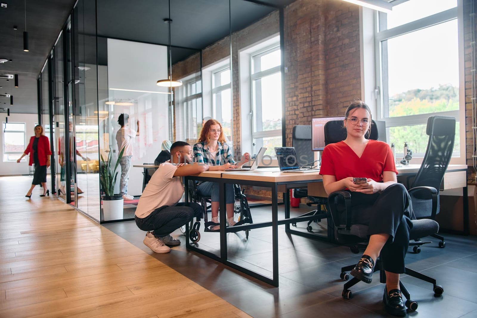 A diverse group of business professionals collaborates in a modern startup coworking center, utilizing a mix of paper-based and technological tools such as mobile phones and computers by dotshock