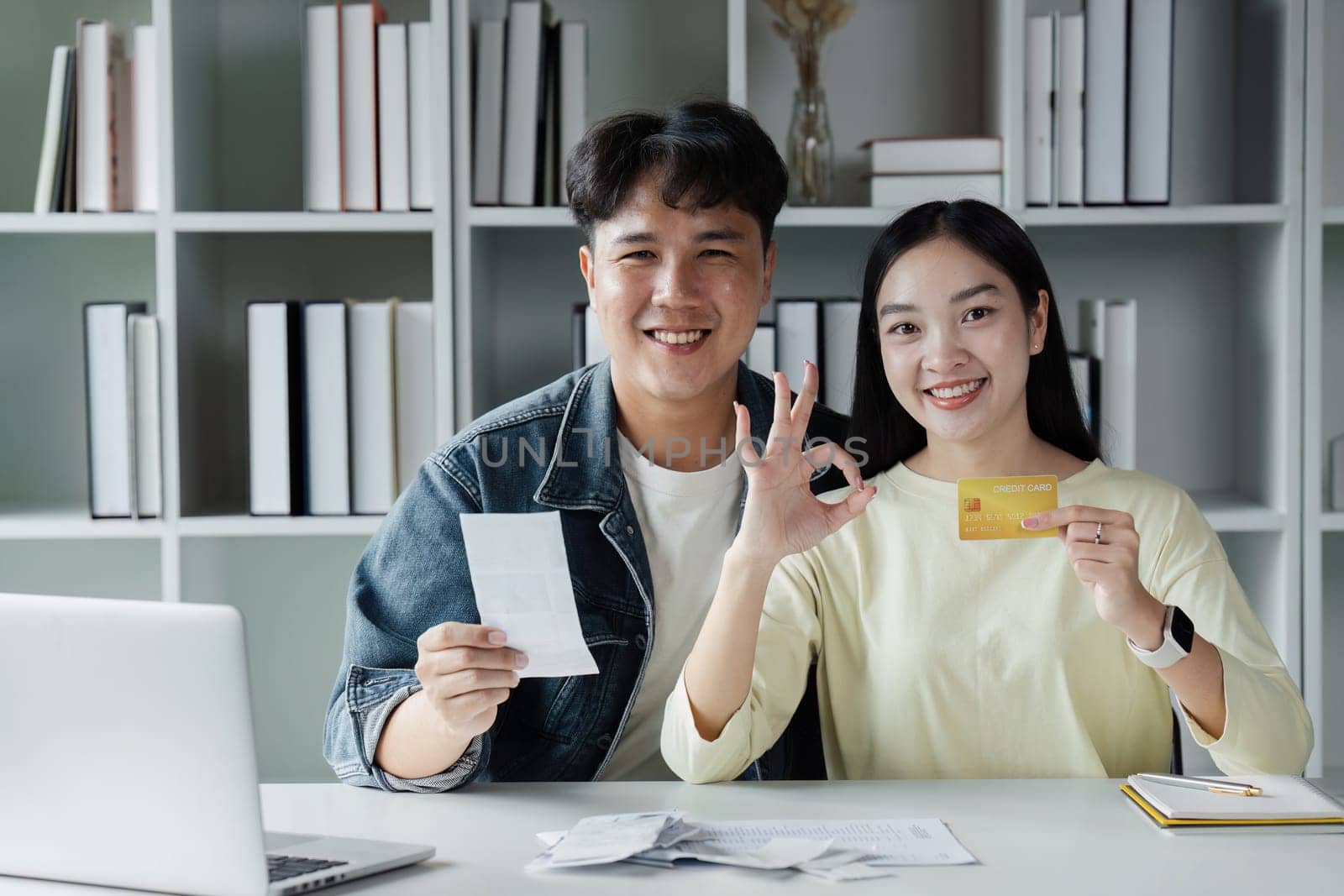 Happy young couple Checking Financial Documents And Calculating Budget At Home. paying taxes, saving money concept.