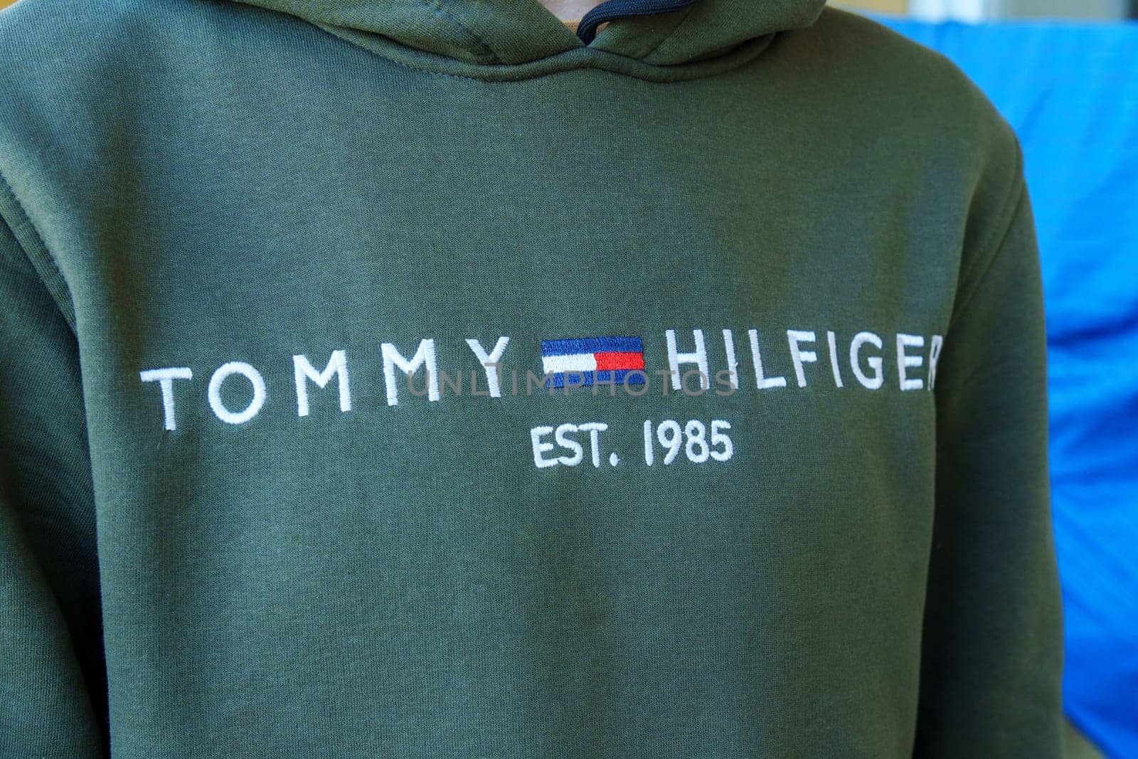 Tyumen, Russia-January 11, 2024: Person in Green Tommy Hilfiger Sweatshirt close up logo. Selective focus by darksoul72