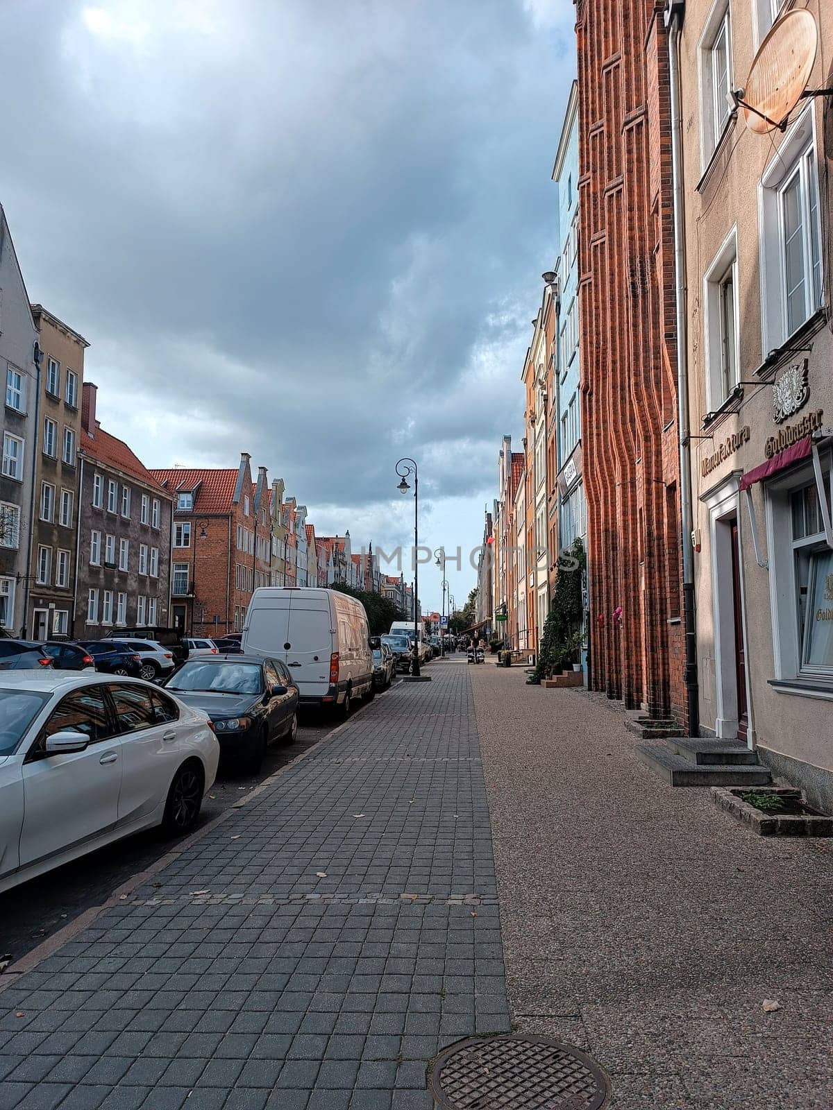 Gdansk, Poland, city center, historical street view with cars parked in the cloudy day by Kaliada