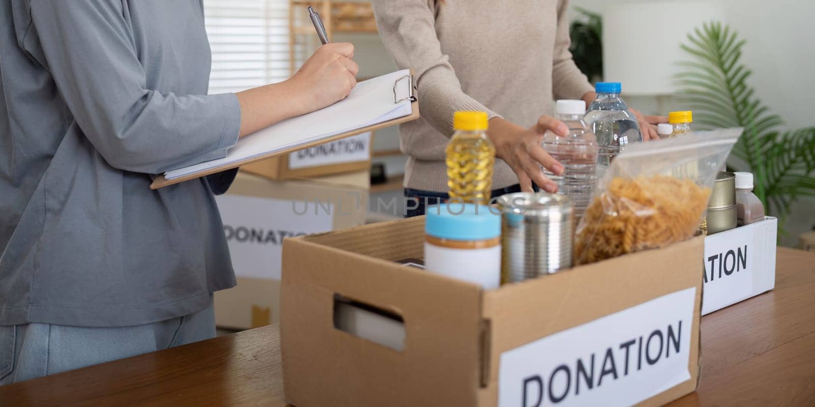 Volunteer preparing free foodstuff rations for poor people. Charity two woman of the community work together. concept of giving and humanitarian aid.