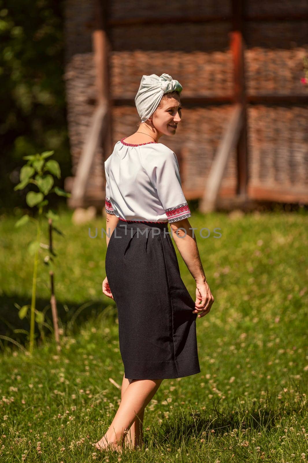 a woman in Ukrainian national costume walks on the lawn