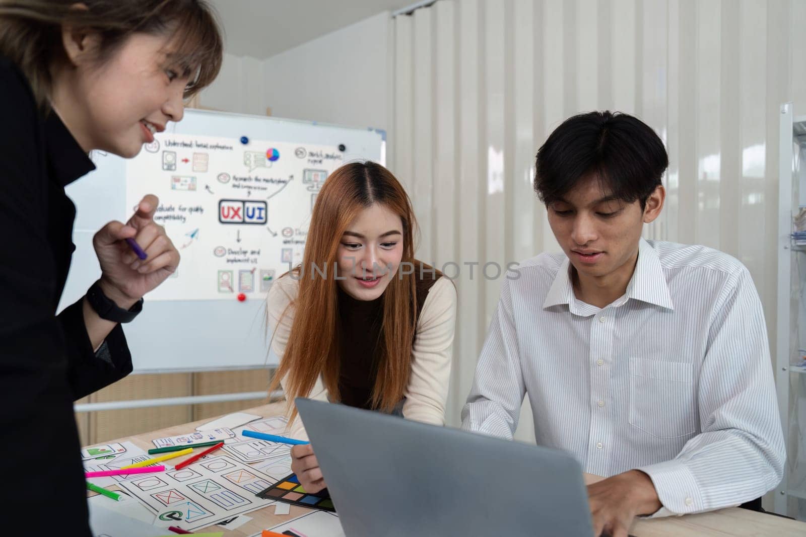 ux developer and ui designer presenting mobile app interface design on whiteboard in meeting at office. Creative digital development mobile app agency. digital transformation.