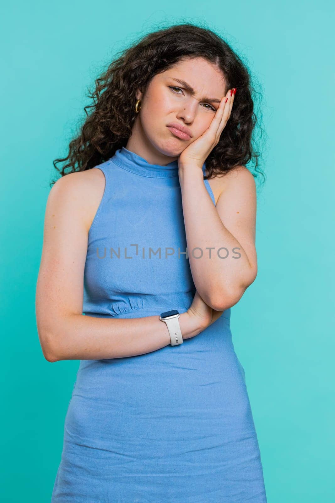 Sad woman feeling hopelessness loneliness, nervous breakdown, loses becoming surprised by lottery results, bad fortune, loss unlucky news. Young adult girl isolated on studio blue background. Vertical