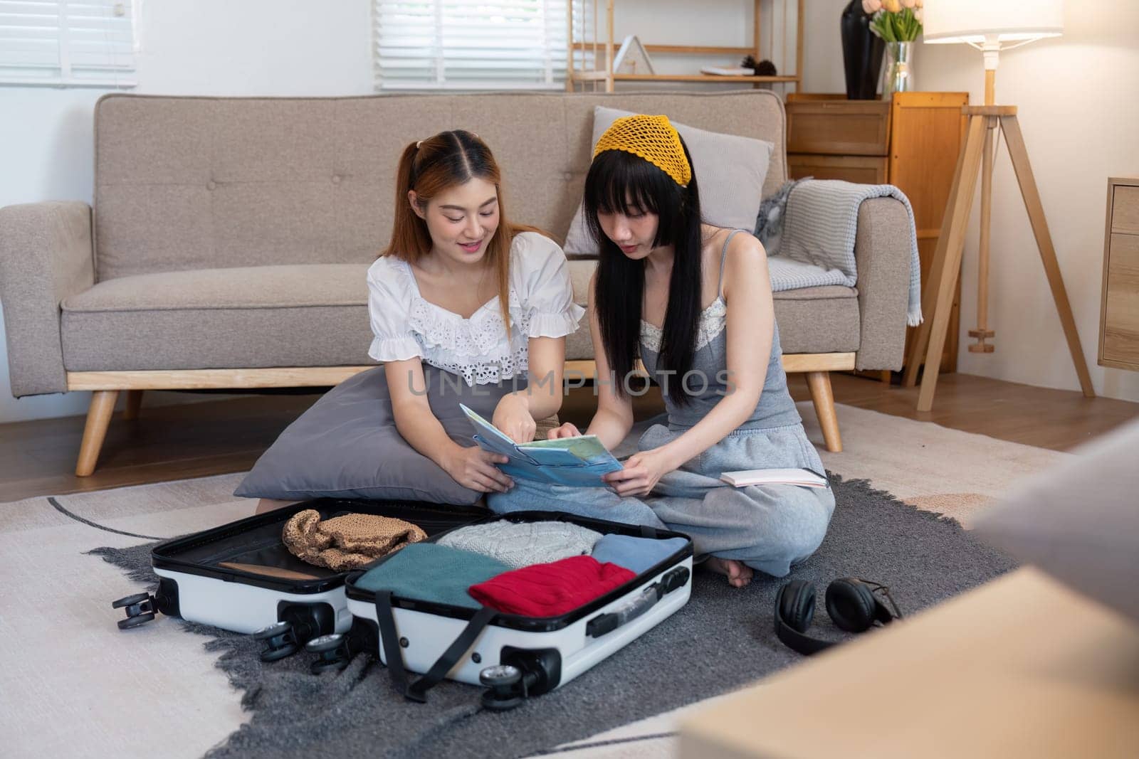 Friendship. Travel together. Two asian young woman friends packing for summer vocation. preparation planning concept by nateemee