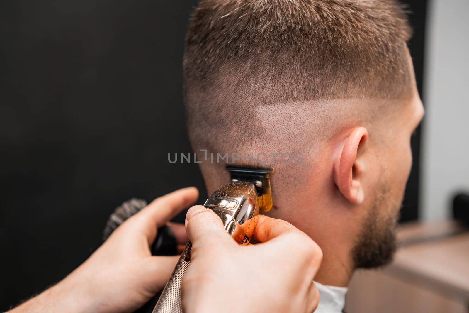 Master cuts man hair using comb and trimmer in barbershop by vladimka