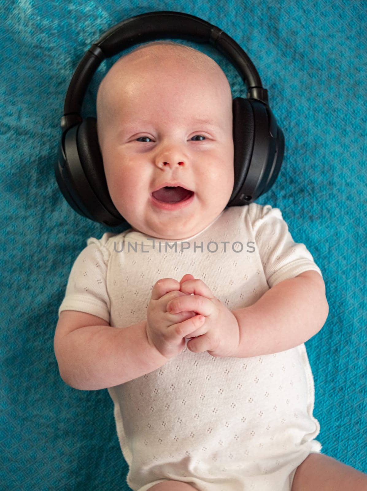 Little boy on blue blanket background with headphones
