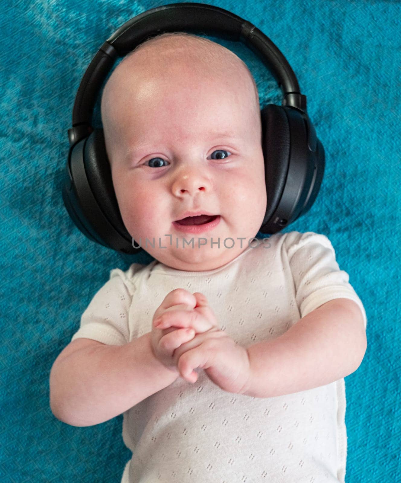 Little boy on blue blanket background with headphones