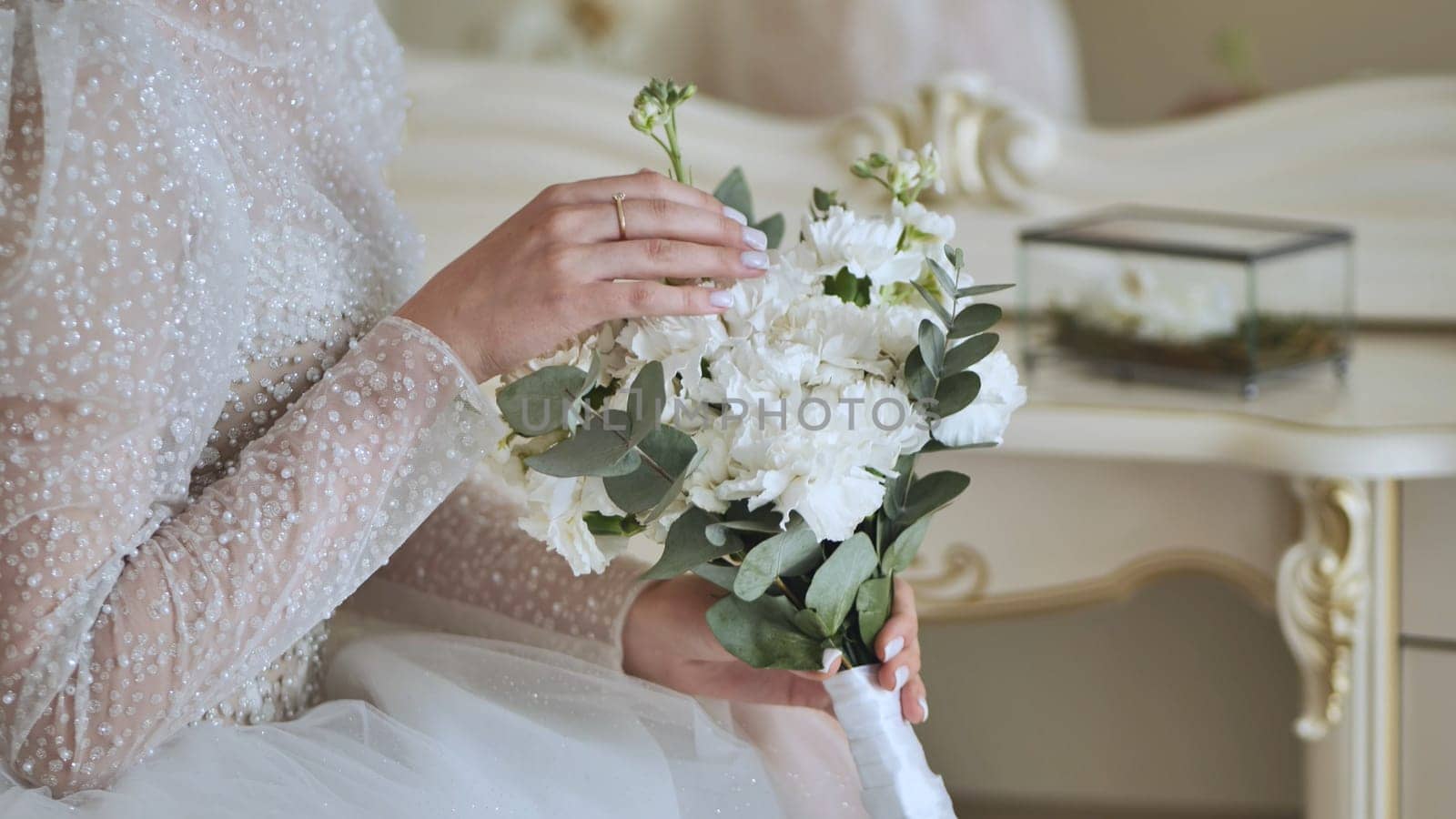 The bride touches the bouquet of flowers. by DovidPro