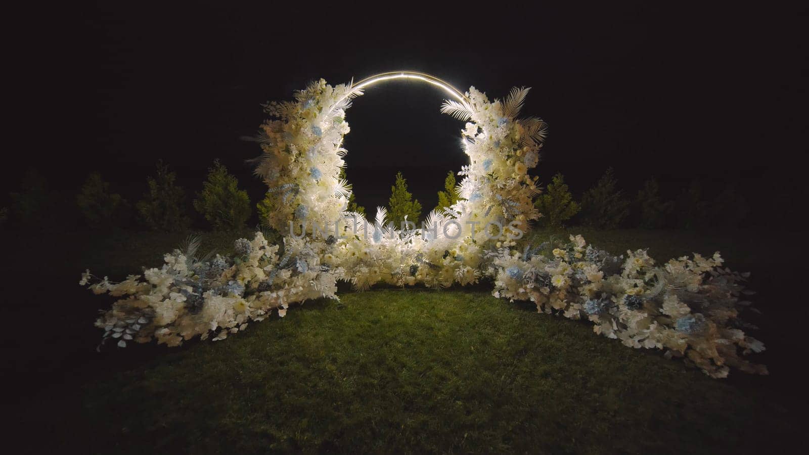 Wedding arch decorated with flowers at night. by DovidPro