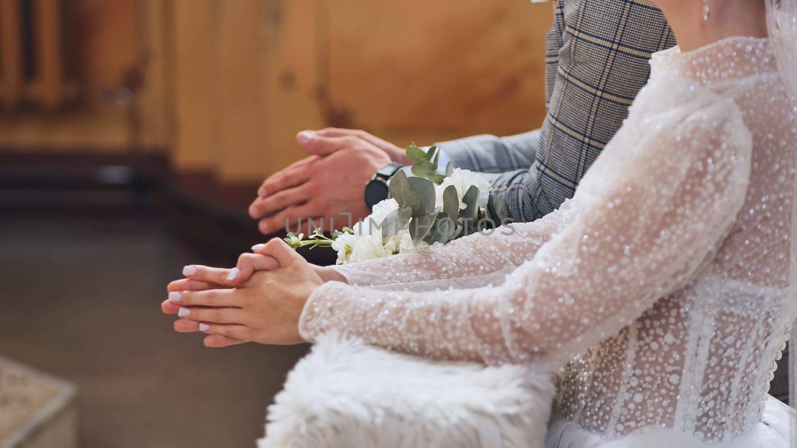 A bouquet of flowers among newlyweds in a Catholic church during a wedding. by DovidPro