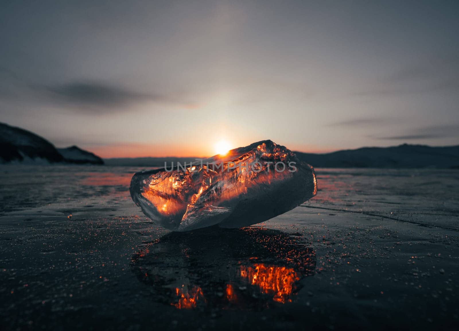 Ice crystal on the frozen surface of Lake Baikal in early morning. Sky and sun reflections on the ice surface. Amazing winter landscape. Winter tourist season at lake Baikal by Busker