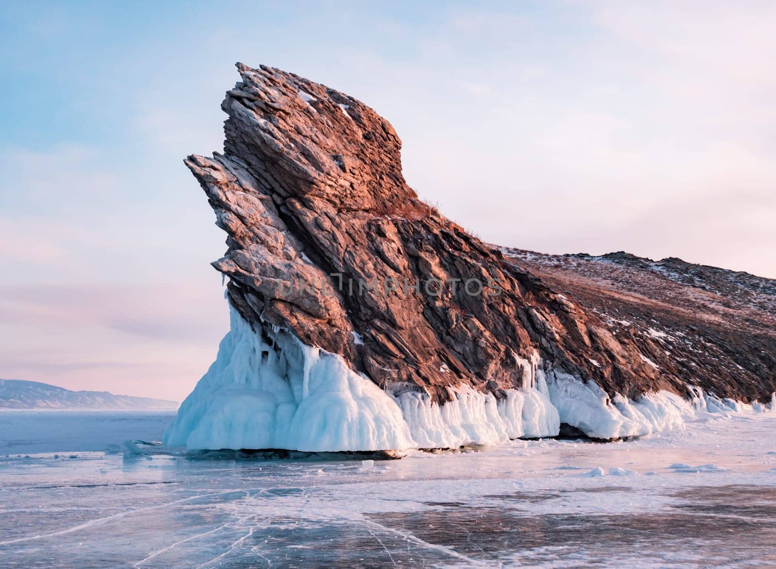 Ogoy island on winter Baikal lake. Winter scenery of Dragon Tail Rock on Ogoy island during sunrise at Lake Baikal. by Busker