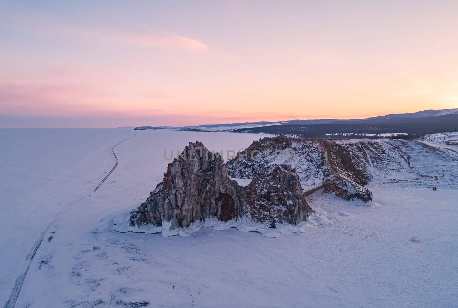 Aerial shot of a Shamanka rock on Olkhon island at sunset. Winter landscape. Popular touristic destination. Natural landmark. Panoramic view by Busker