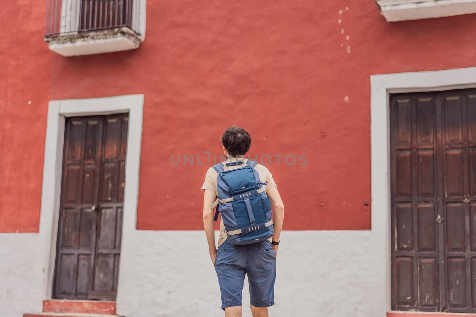 Man tourist explores the vibrant streets of Valladolid, Mexico, immersing herself in the rich culture and colorful architecture of this charming colonial town by galitskaya
