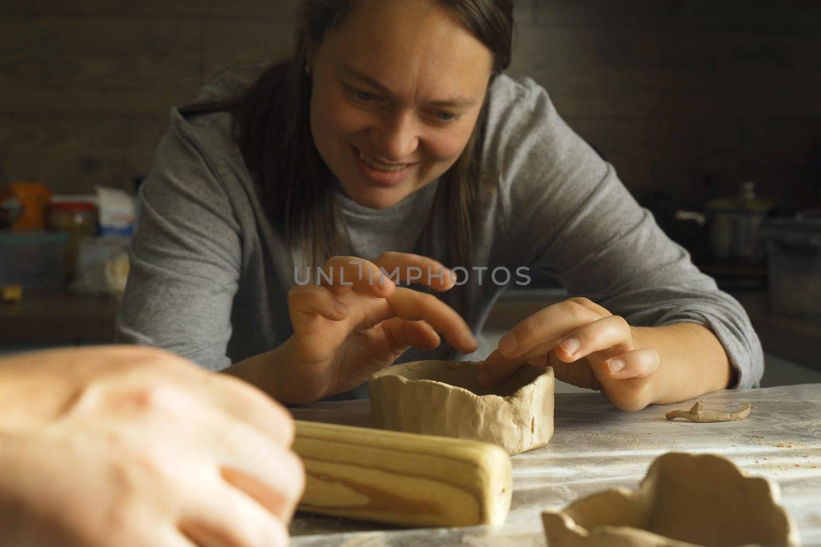 A woman makes a clay product with her hands - a ceramic pot. Close-up. Creative hobby.