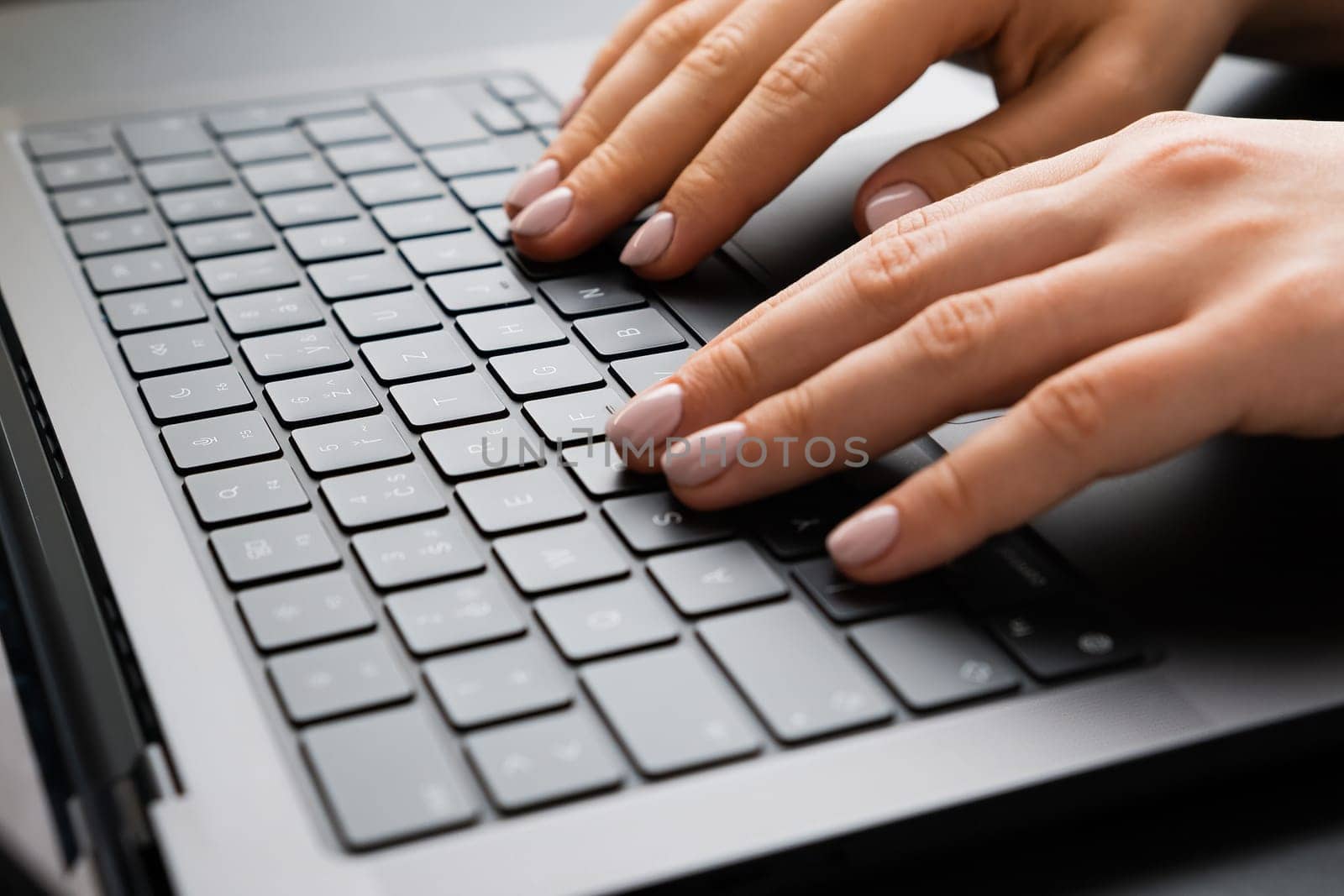 BERLIN, GERMANY - APRIL 14 2024: Female hand working on a laptop keyboard. Business office workplace concept