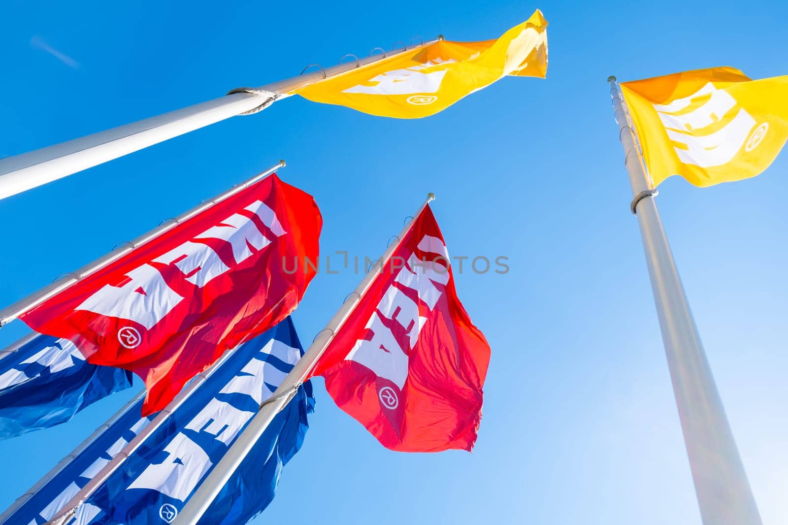 PRAGUE, CZECHIA -APRIL, 2024: Red, blue and yellow IKEA flags waving against blue sky