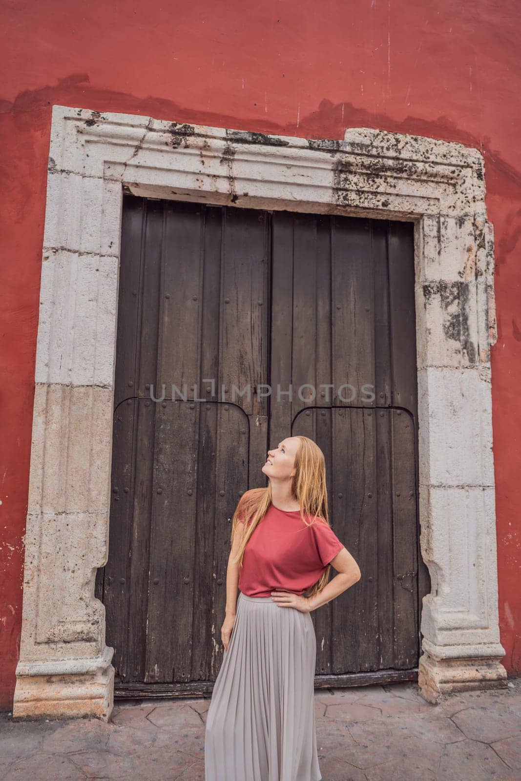 Woman tourist explores the vibrant streets of Valladolid, Mexico, immersing herself in the rich culture and colorful architecture of this charming colonial town by galitskaya