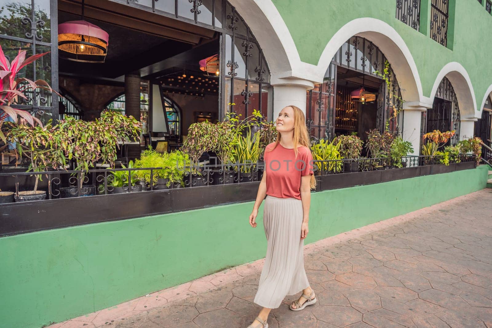 Woman tourist explores the vibrant streets of Valladolid, Mexico, immersing herself in the rich culture and colorful architecture of this charming colonial town by galitskaya