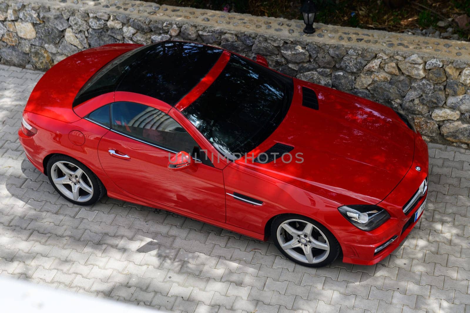 Gaziveren Cyprus 04.18.2024-red Mercedes Benz in the parking lot near the house