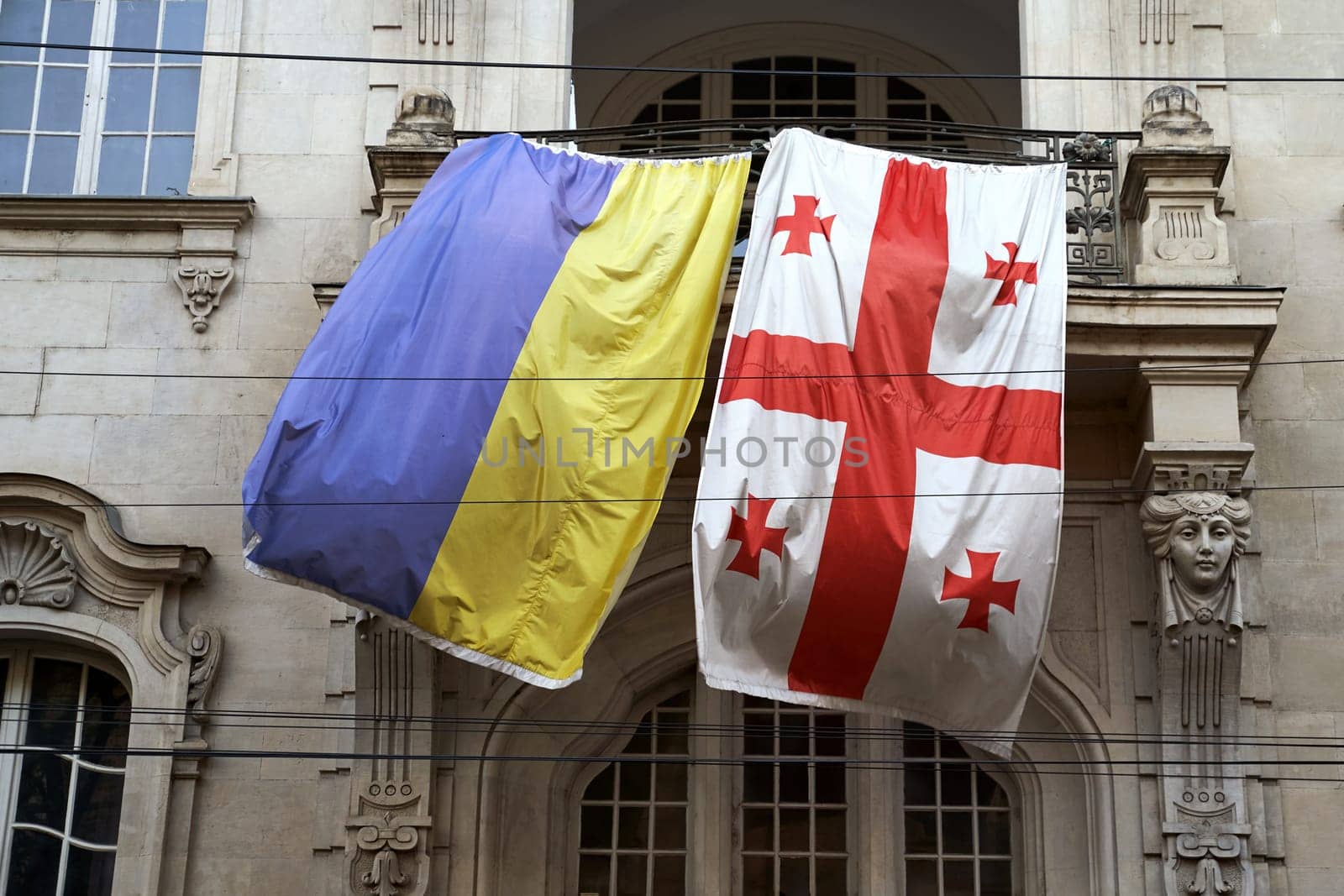 Flags of Ukraine and Georgia waving on the balcony of an old building in Tbilisi, Georgia by berezko