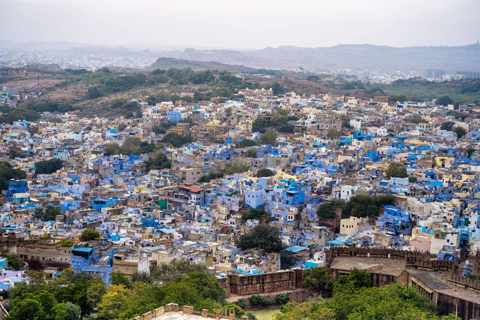 aerial drone shot showing jodhpur blue city cityscape showing traditional houses in middle of aravalli with colorful densely packed houses India
