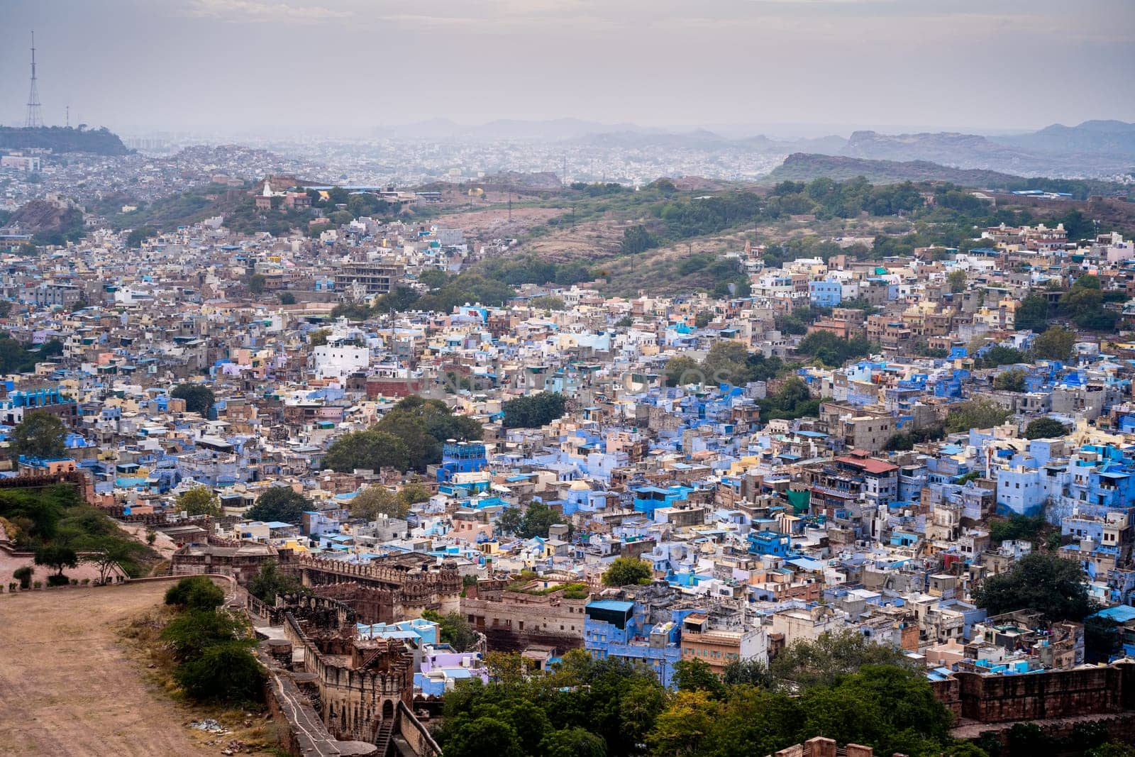 aerial drone shot showing jodhpur blue city cityscape showing traditional houses in middle of aravalli with colorful densely packed houses by Shalinimathur